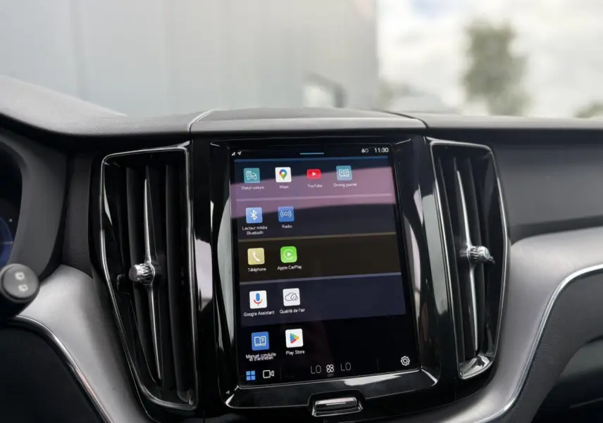 Écran tactile central 9 pouces du Volvo XC60 T6 AWD PHEV rouge, avec commandes multimédia et aérateurs noirs.