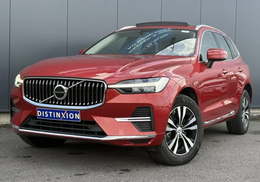 Vue 3/4 avant du Volvo XC60 T6 AWD PHEV rouge Fusion avec calandre chromée et jantes alliage 18 pouces.
