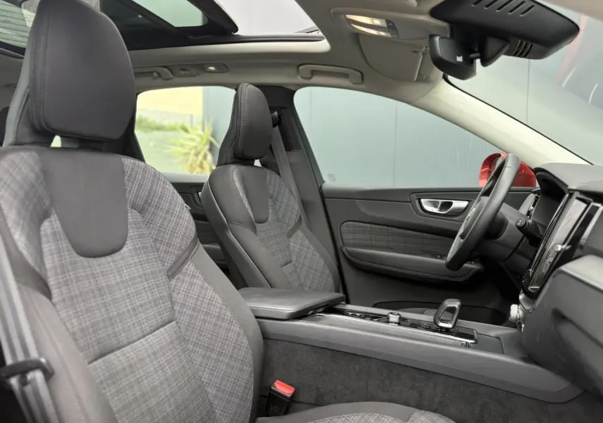 Intérieur du Volvo XC60 T6 AWD PHEV 2024 vu côté droit, sièges tissu à motif écossais et toit ouvrant panoramique.