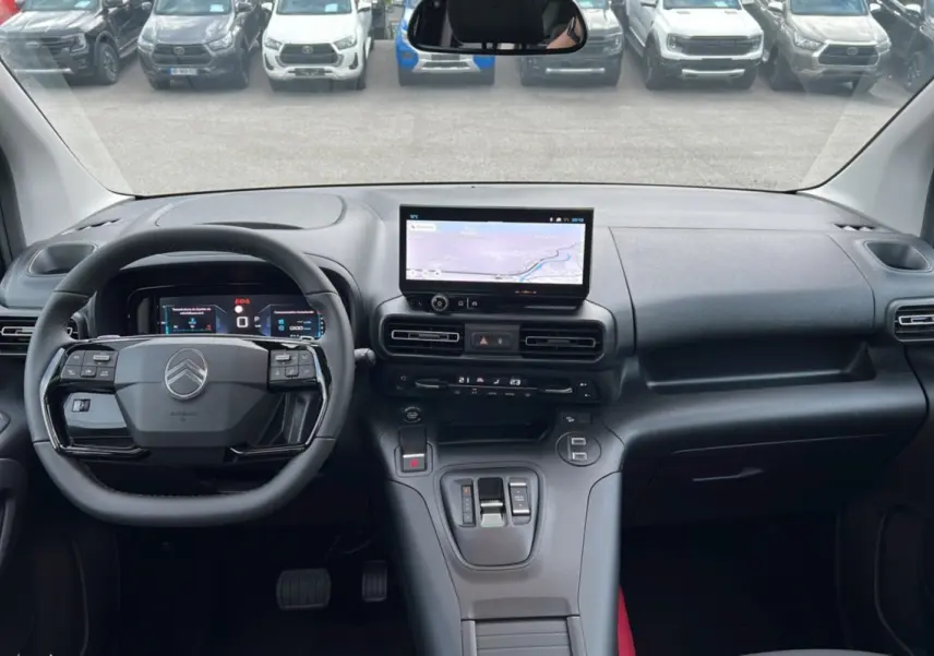 Intérieur du Citroën Berlingo 2025 en vue frontale, tableau de bord moderne avec écran tactile et volant multifonction noir.