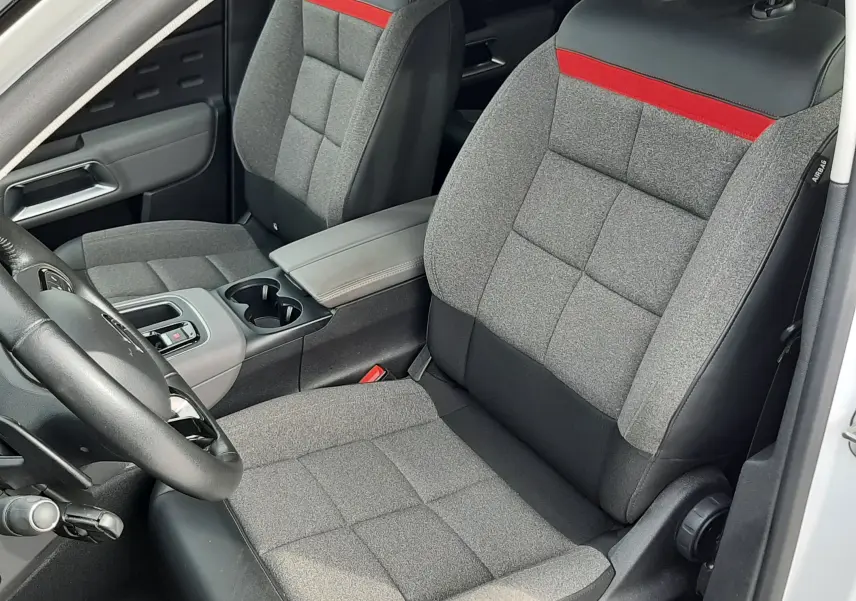 Vue intérieure côté conducteur du Citroën C5 Aircross blanc 2020, sièges gris avec bande rouge et console centrale.
