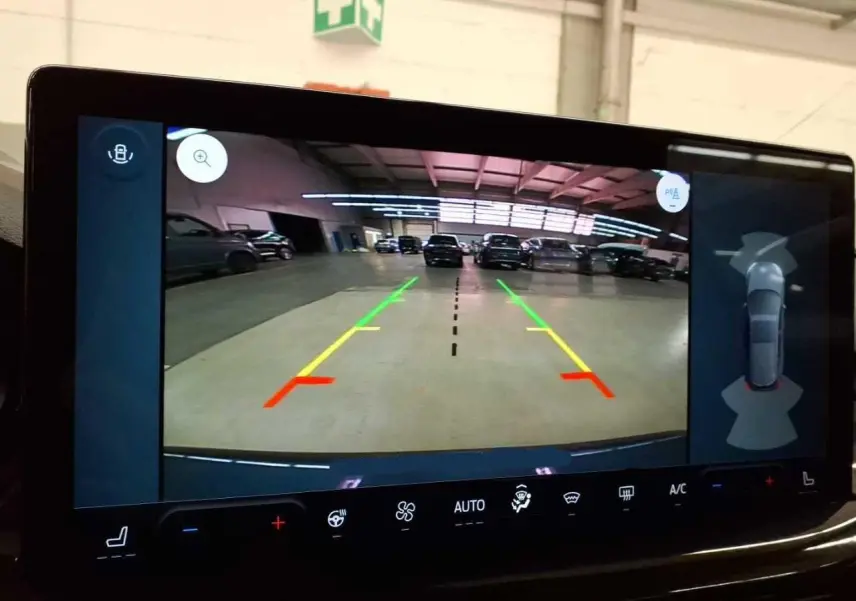 Vue de l'écran de caméra de recul du Ford Focus SW bleu azur, avec lignes d'aide au stationnement et attelage visible.