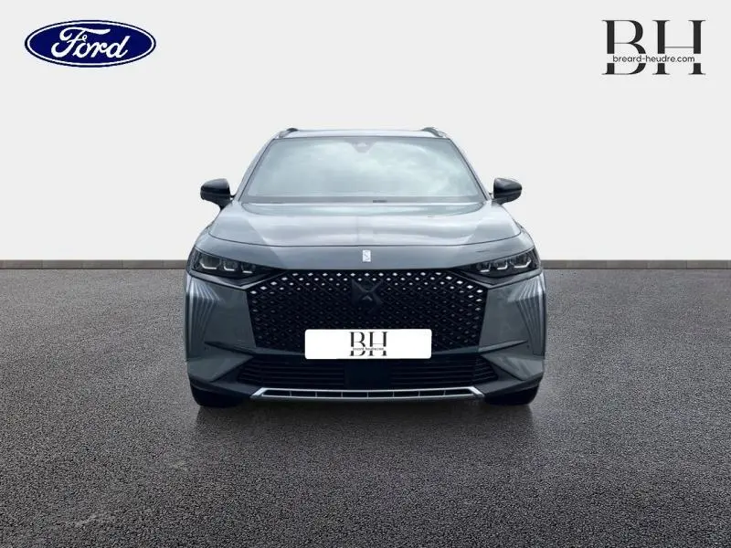 Vue avant frontale d'un DS7 BlueHDi 130ch Opera gris laqué avec calandre noire à motif losanges et phares LED fins.