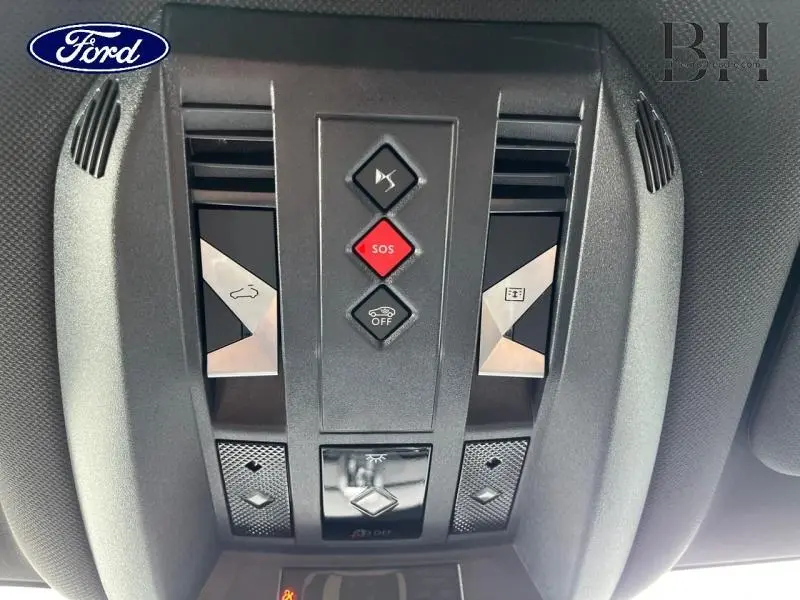 Vue en plongée sur le panneau de commande intérieur gris foncé avec boutons SOS et ouverture toit ouvrant du DS7 2023.