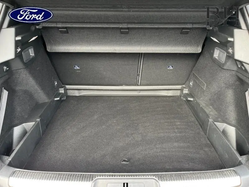 Coffre spacieux et propre d'un DS7 Gris Laqué, vue intérieure arrière avec revêtement noir et banquette rabattable.