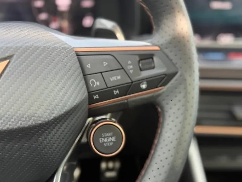 Gros plan sur le volant perforé et les commandes du CUPRA Formentor 2.0 TDI 150ch avec bouton start/stop, finition gris graphène.