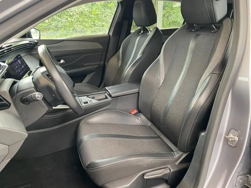 Intérieur avant droit de la Peugeot 308 2022 gris Artense, sièges en tissu et cuir avec console centrale moderne.