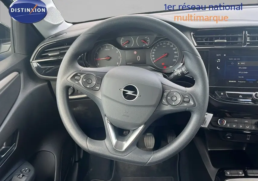Vue intérieure centrée sur le volant Opel d'une Corsa 2025, avec tableau de bord et écran tactile visibles.