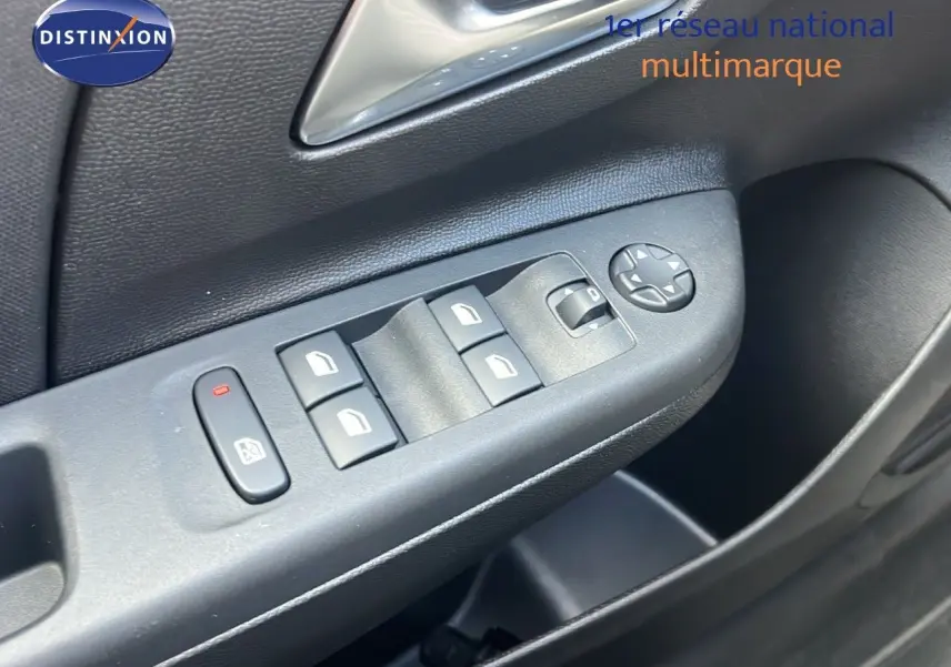 Gros plan sur la commande des vitres électriques côté conducteur de l'Opel Corsa bleu Voltaik métal, finition 2025.