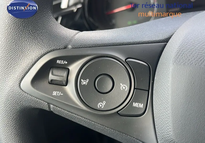 Gros plan sur les commandes de régulateur de vitesse au volant d'une Opel Corsa bleu Voltaik Metal 2025.