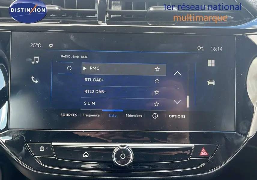 Écran tactile central de la console d'une Opel Corsa bleu Voltaik Metal, affichant les stations radio numériques.