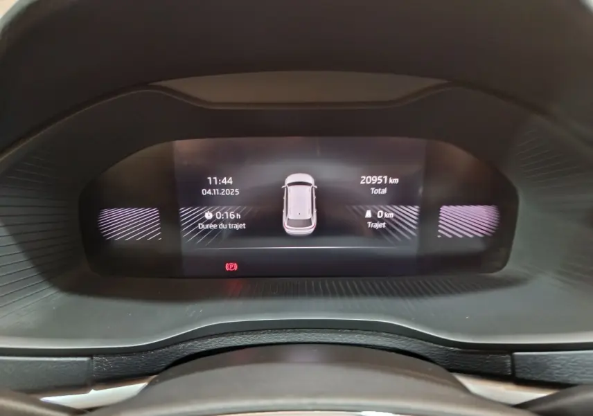 Affichage numérique du combiné d'instruments du Skoda Karoq blanc, montrant la distance totale et durée du trajet.
