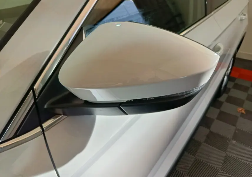 Rétroviseur côté gauche blanc du Skoda Karoq 2.0 TDI 116ch Selection 2024 avec clignotant intégré.