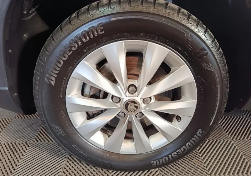 Gros plan sur la jante alliage argentée et pneu Bridgestone d'un Skoda Karoq blanc, détail de la roue avant.