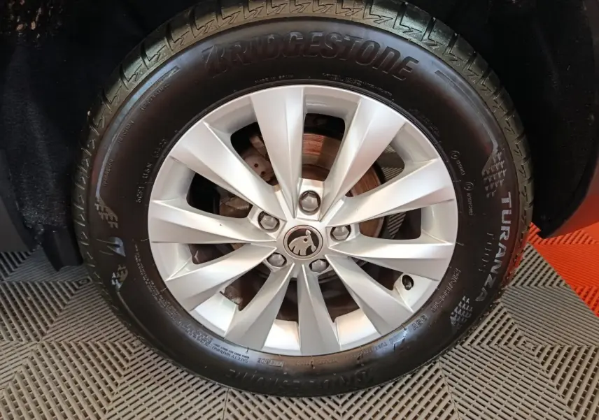 Gros plan sur la roue avant droite du Skoda Karoq blanc, jante alliage à 10 branches et pneu Bridgestone Turanza.