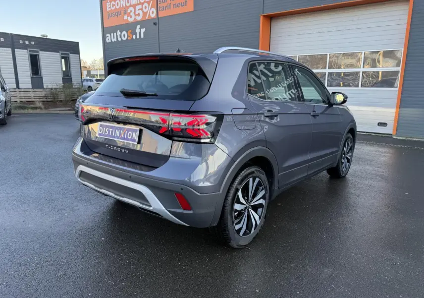 Volkswagen T-Cross gris cendre vu de l'arrière côté gauche, avec feux LED et jantes alliage distinctives.