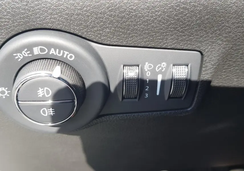 Gros plan sur le bouton de commande des phares et réglages d’éclairage du Jeep Compass blanc 2024.