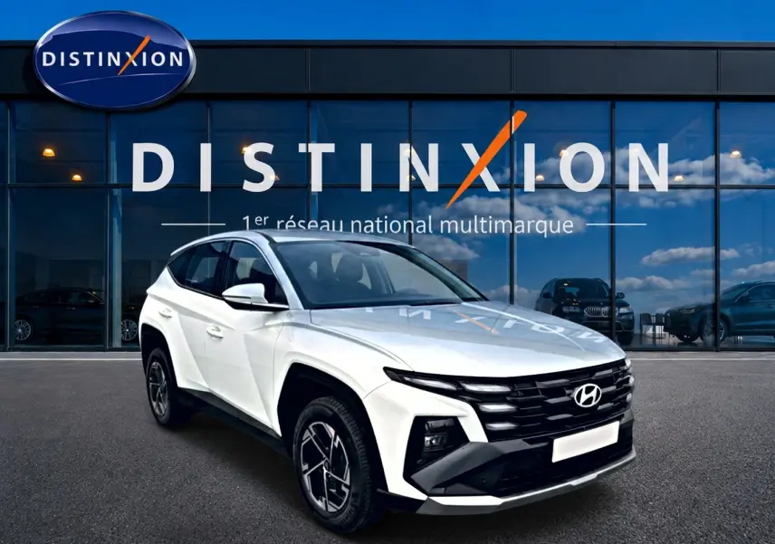 Hyundai Tucson blanc 2026 en 3/4 avant droit, avec calandre noire et jantes alliage 17 pouces visibles.