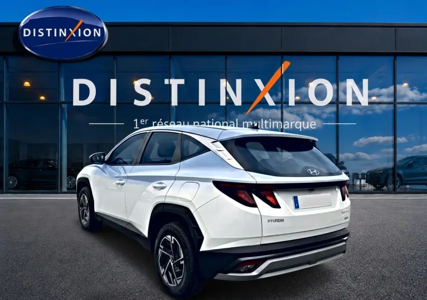 Vue 3/4 arrière droite du Hyundai Tucson blanc 2026 avec jantes alliage et feux arrière LED distinctifs.