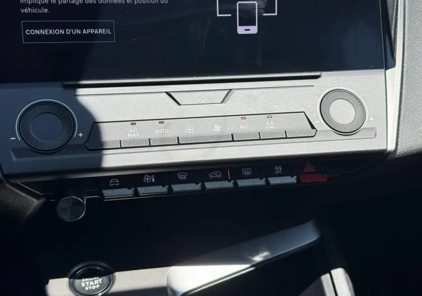 Vue rapprochée de la console centrale de la Peugeot e-308 gris Artense, montrant l'écran tactile et les commandes climatisation.