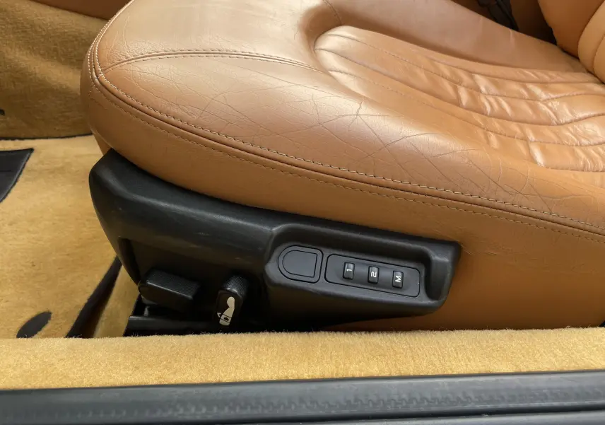 Gros plan sur le siège en cuir marron clair de la Maserati Spyder 2002 avec commandes électriques de réglage mémoire.