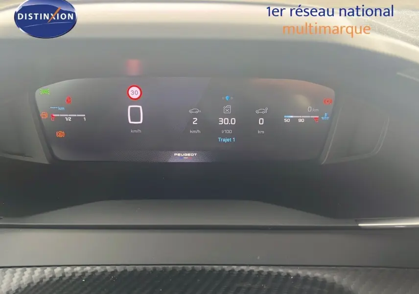 Tableau de bord numérique du Peugeot 2008 blanc, affichant vitesse et informations de conduite en vue frontale.