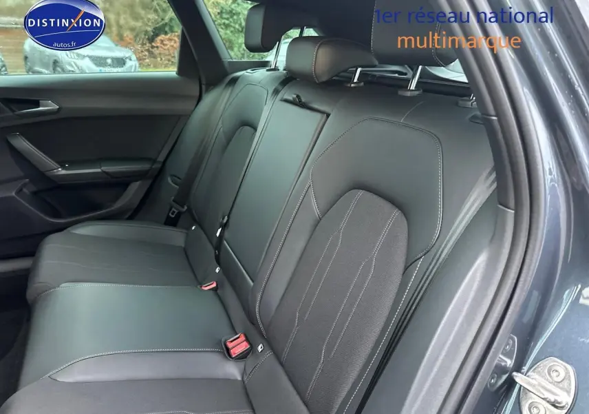 Vue intérieure côté arrière droit sur la banquette en cuir noir du CUPRA LEON ST gris magnétique avec ceintures et appuie-têtes.