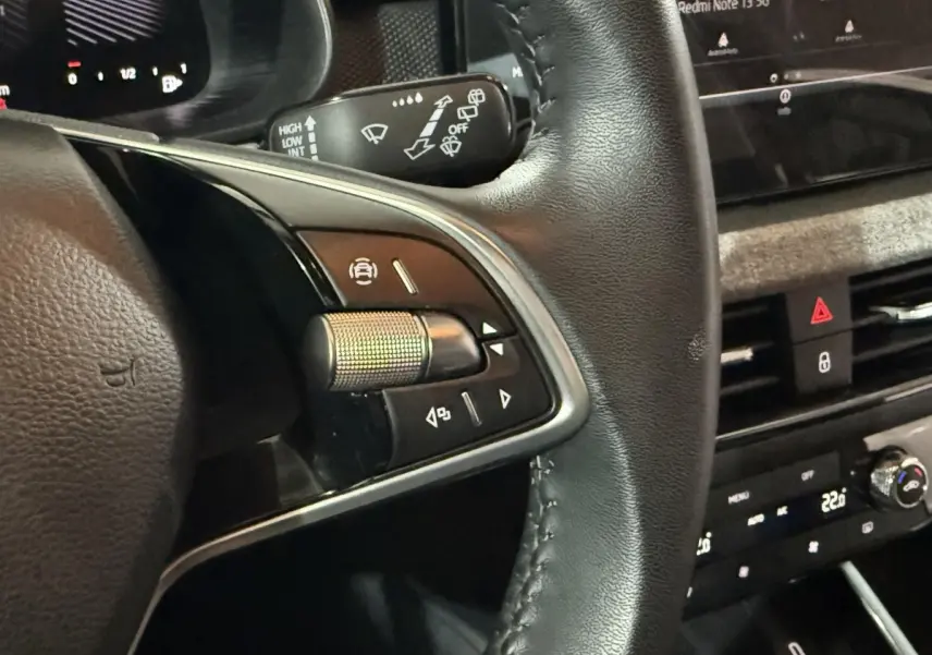 Gros plan sur le volant cuir côté gauche du Skoda Kamiq 2024 avec commandes multifonctions et tableau de bord digital.