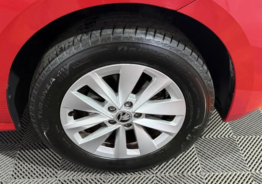 Gros plan sur la roue avant gauche rouge d’un Skoda Kamiq 2024 avec jante argentée et pneu Bridgestone Turanza.