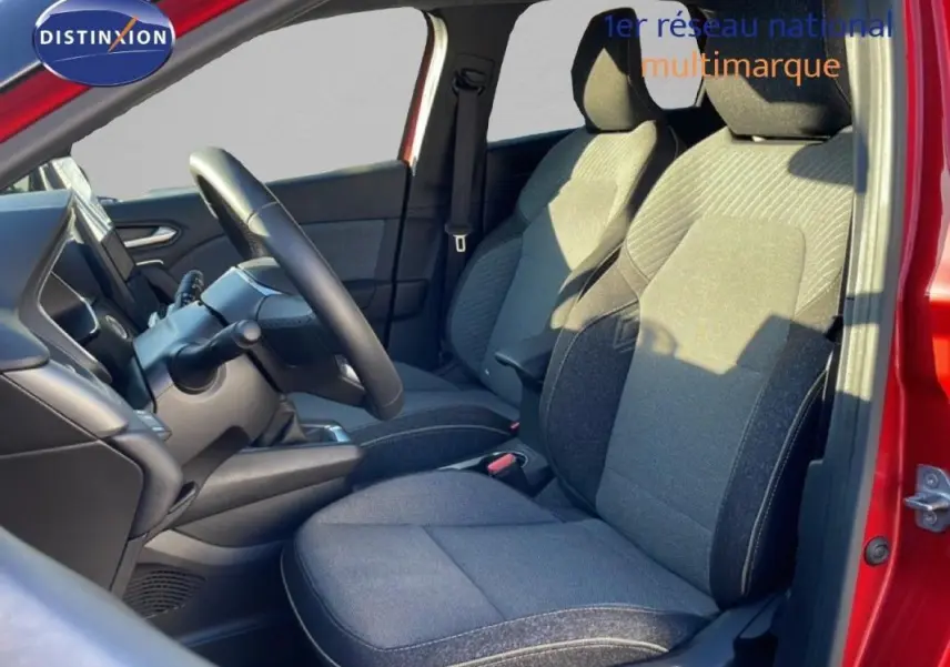 Vue intérieure côté gauche du Renault Captur rouge 2025, montrant les sièges avant et le volant multifonctions en cuir.