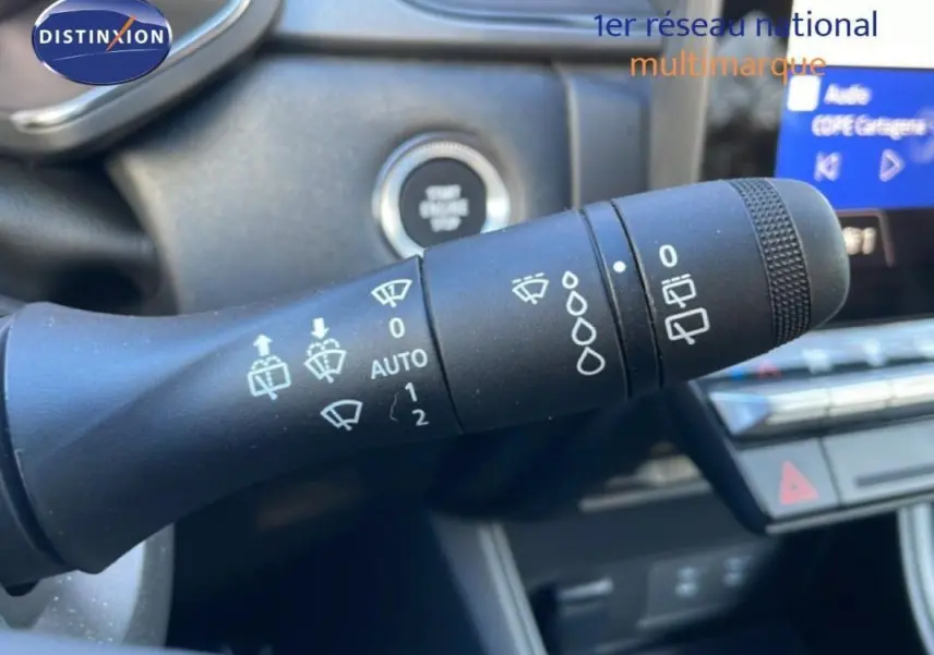 Gros plan sur la commande de détecteur de pluie dans l'habitacle du Renault Captur rouge 2025.