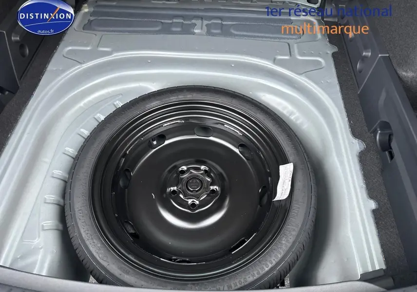 Vue plongeante sur la roue de secours noire dans le coffre gris magnétique du CUPRA LEON ST 1.5 etsi hybrid 2025.