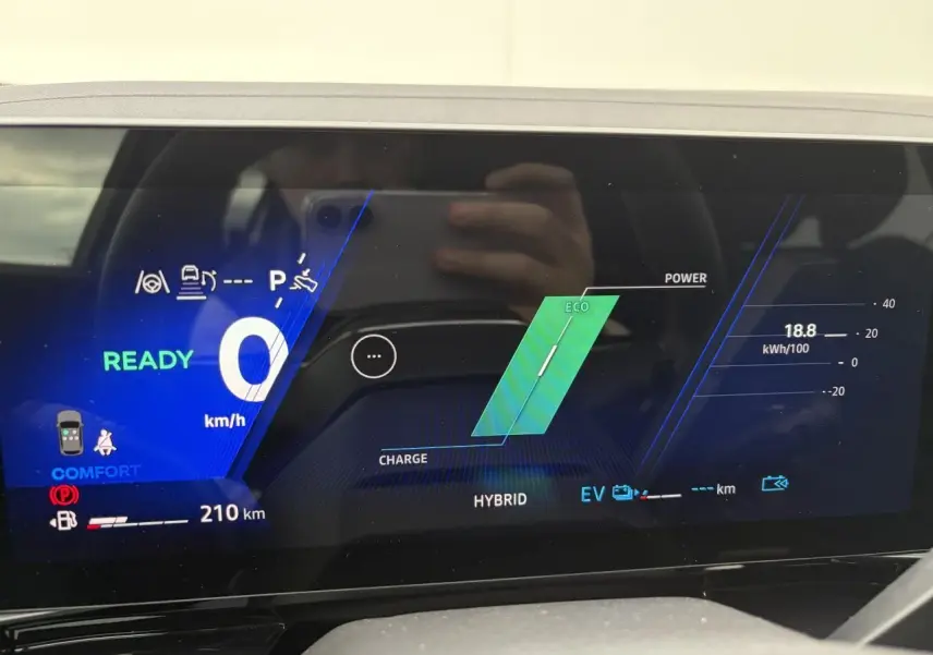 Tableau de bord numérique du Renault Rafale 2025 en mode hybride, affichant vitesse zéro et autonomie 210 km.