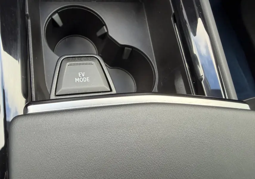 Gros plan sur la console centrale noire avec bouton EV MODE et porte-gobelets du Renault Rafale Summit Blue hybride rechargeable.