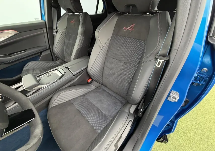 Vue intérieure côté conducteur du Renault Rafale Summit Blue 2025, sièges sport en Alcantara avec logo Alpine rouge brodé.