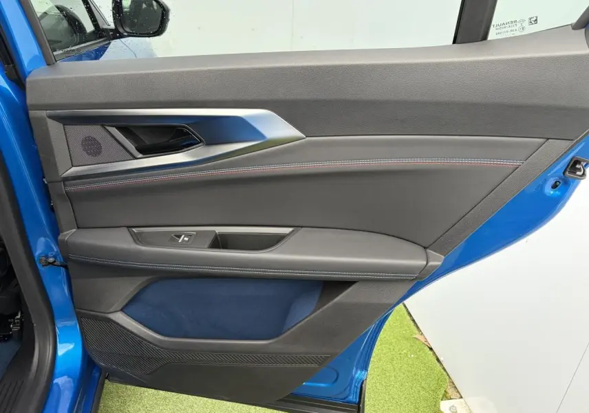Vue intérieure côté gauche de la porte avant d'une Renault Rafale Summit Blue avec surpiqûres tricolores et insert textile bleu.