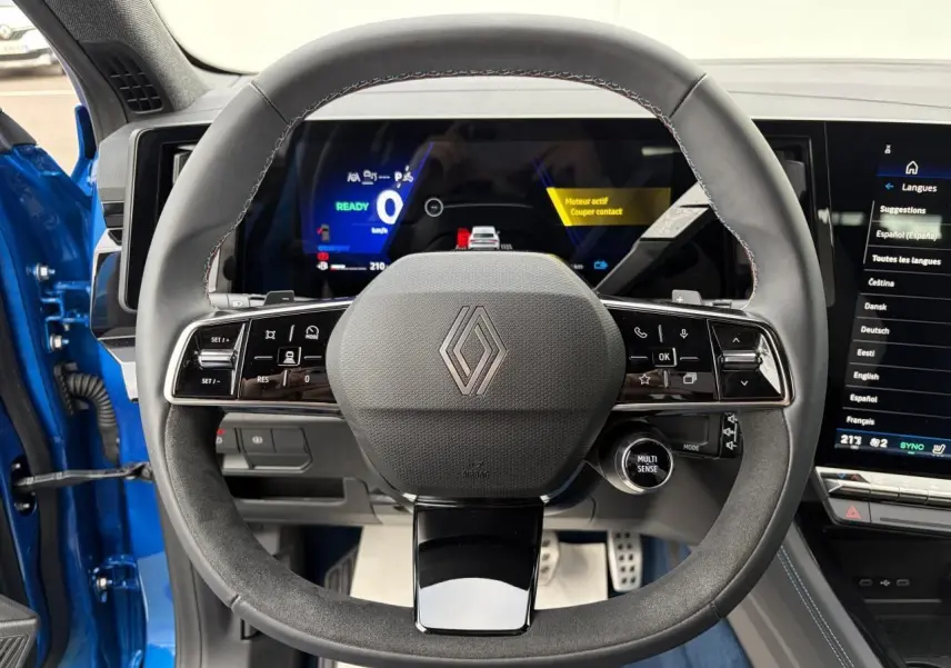 Vue centrée sur le volant Alcantara du Renault Rafale Summit Blue avec tableau de bord digital et écran tactile.
