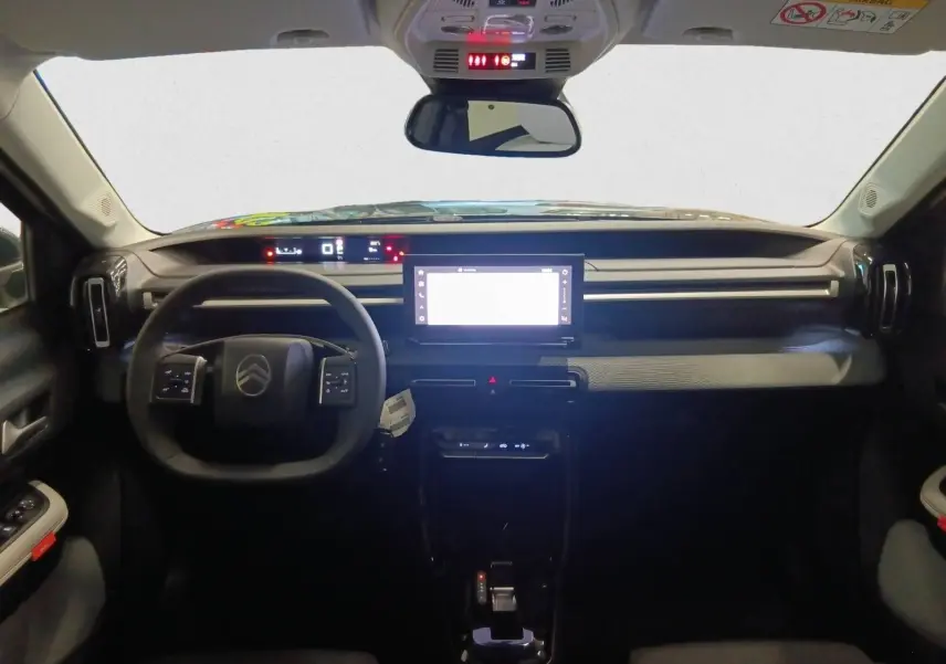 Intérieur du Citroën C3 Aircross 2025 vu de face, tableau de bord moderne avec écran tactile central et volant multifonction.