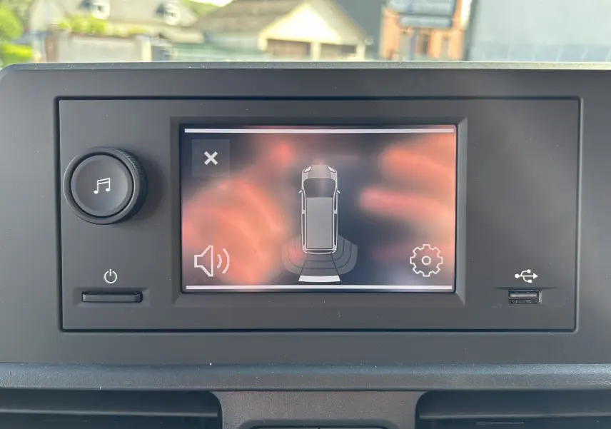 Écran tactile intérieur du Peugeot Partner Dangel 4x4 montrant l'alerte de détection d'obstacle arrière.