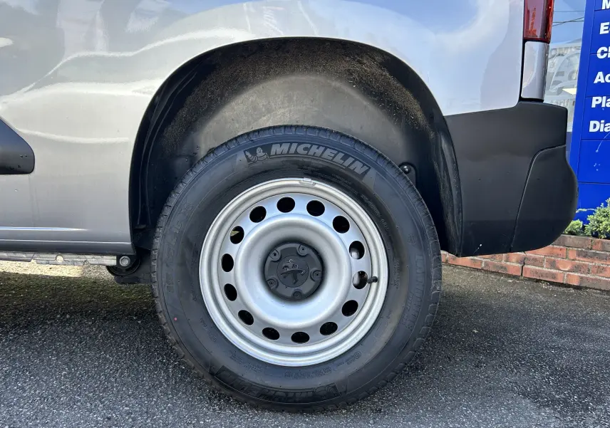 Gros plan sur la roue arrière droite d’un Peugeot Partner Dangel 4x4 gris Artense avec jante acier et pneu Michelin.
