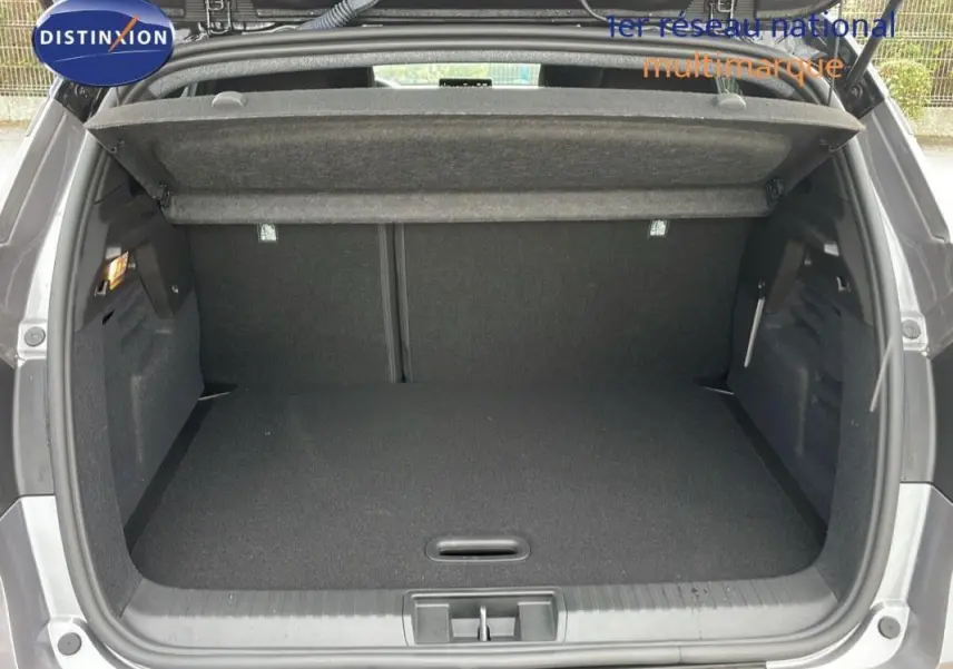 Coffre ouvert vu de l'arrière d'un Renault Captur gris 2025, montrant un espace de rangement vide et propre.