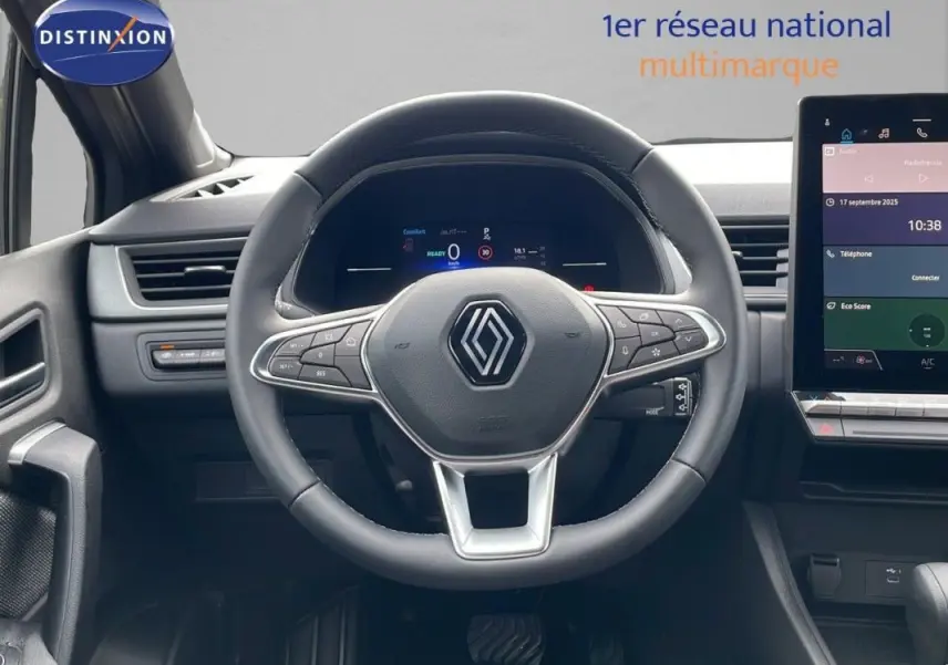 Vue centrée sur le volant cuir et le cockpit numérique du Renault Captur gris 2025 avec écran tactile à droite.