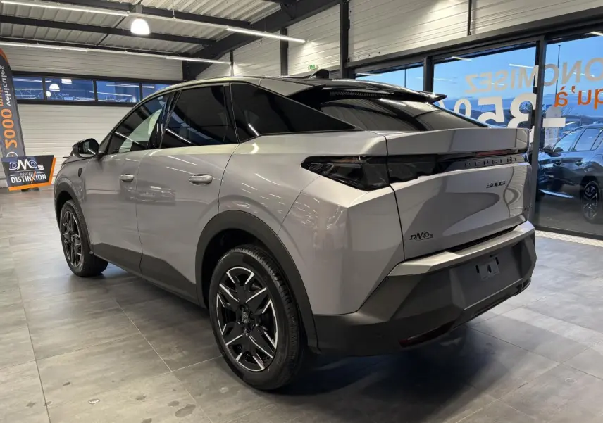 Vue 3/4 arrière droit du Peugeot 3008 gris Artense avec toit noir et jantes alliage 19 pouces en showroom.