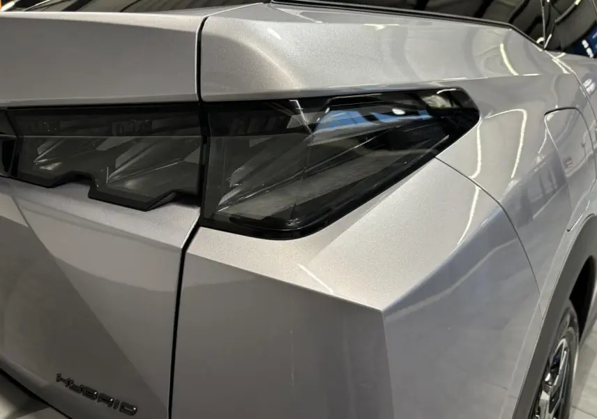 Gros plan sur le feu arrière droit gris Artense du Peugeot 3008 Hybrid 2025 avec lignes anguleuses marquées.