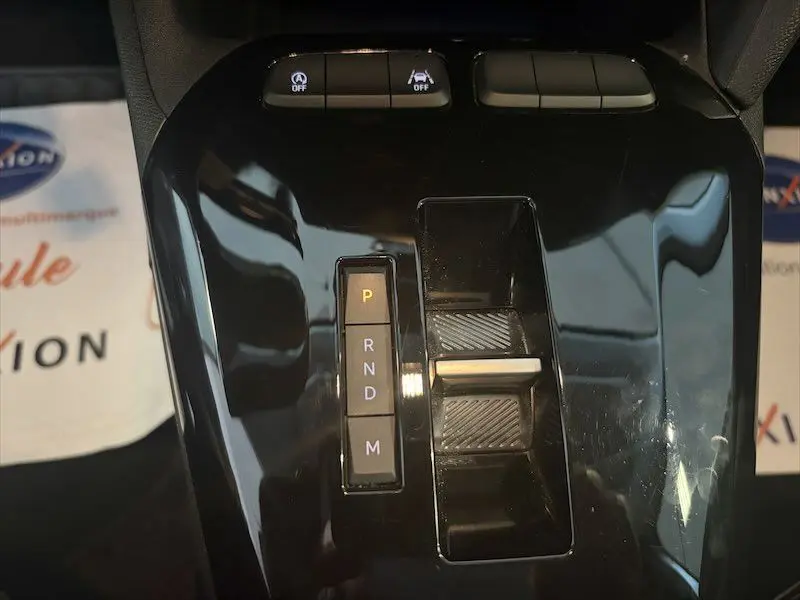 Vue rapprochée de la console centrale noire brillante de l’Opel Corsa 1.2 Turbo 100 Edition 2025 avec sélecteur de boîte auto.