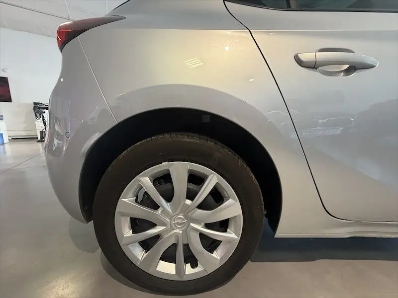 Gros plan sur la roue arrière côté gauche d’une Opel Corsa gris clair 2025, avec jante en alliage et poignée de porte visible.