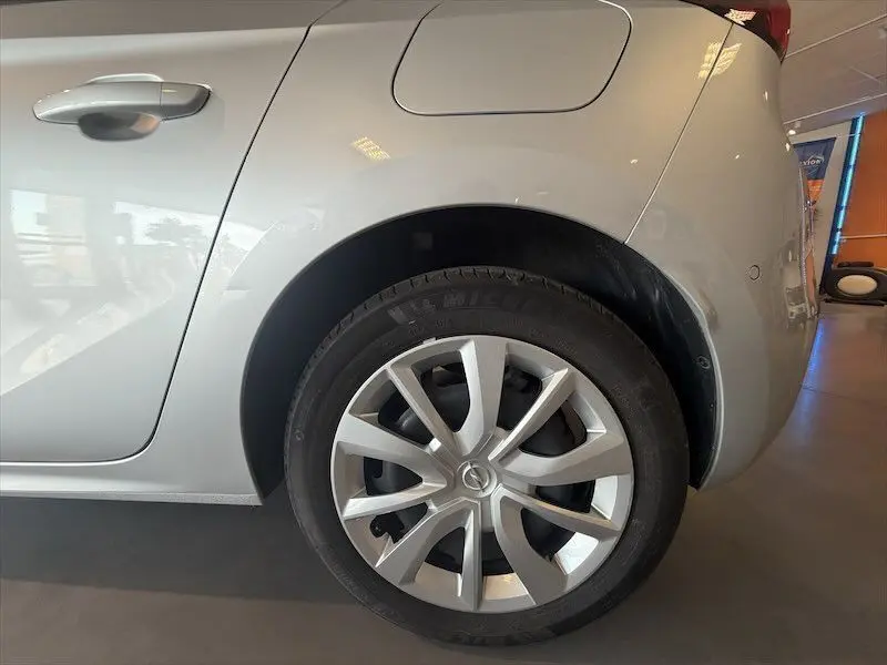 Gros plan sur la roue arrière droite grise d’une Opel Corsa 1.2 Turbo 100 Edition 2025 en intérieur showroom.