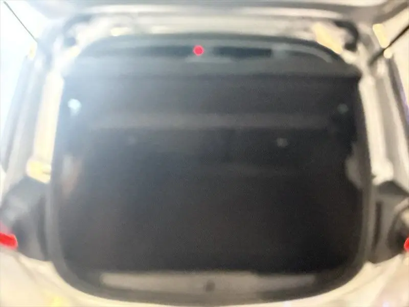 Vue plongeante sur le coffre ouvert d'une Opel Corsa gris 2025, montrant l'espace de chargement intérieur.