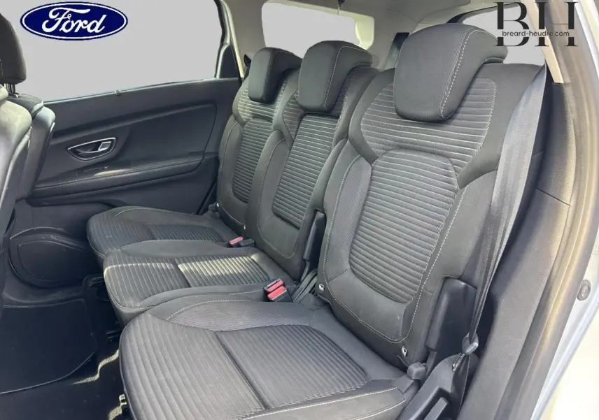 Vue latérale des sièges arrière en tissu carbone foncé d'un Renault Grand Scenic gris platine, montrant trois places avec appuie-têtes.