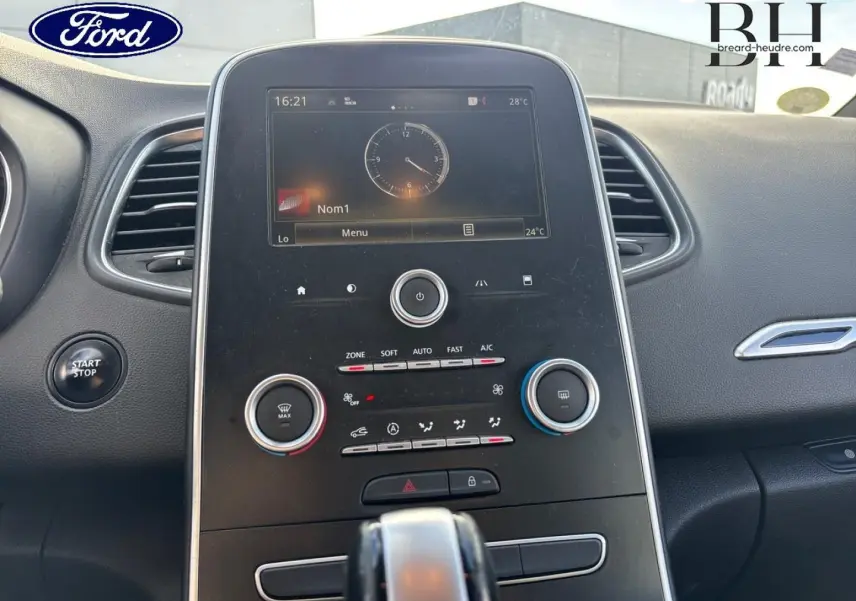 Vue rapprochée du tableau de bord central du Renault Grand Scenic 2017 gris platine, avec écran tactile et commandes climatiques.